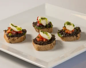 Брускети с маслинова паста, моцарела фьор ди лате, карпачо от чери домати и олио от босилек